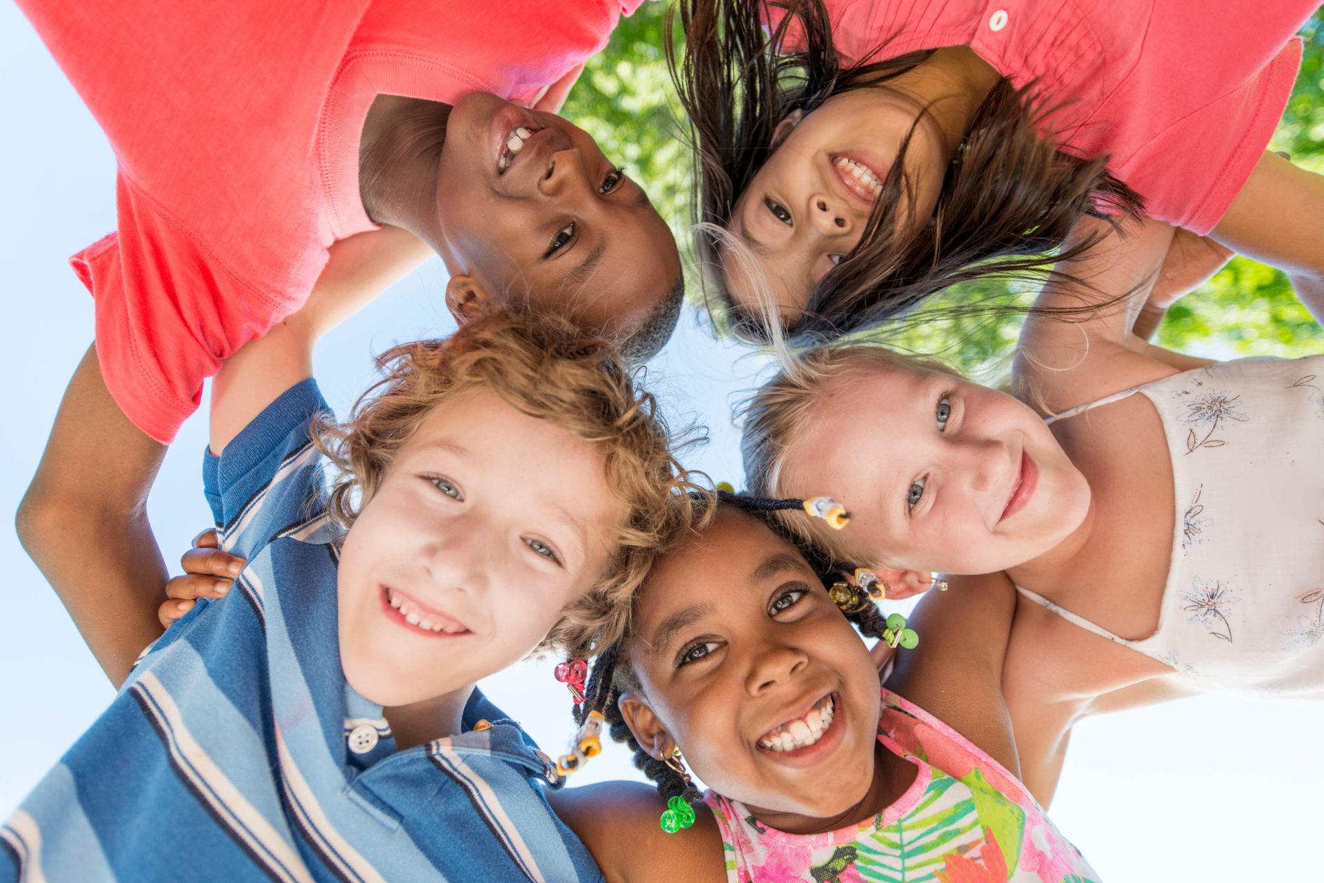 Smiling kids in a huddle at summer camp